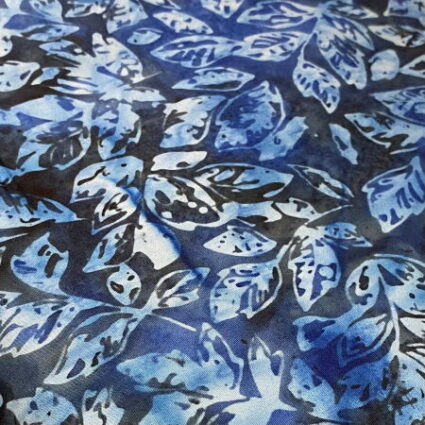 Nutex Blue Haze leaves on a dark blue fabric background
